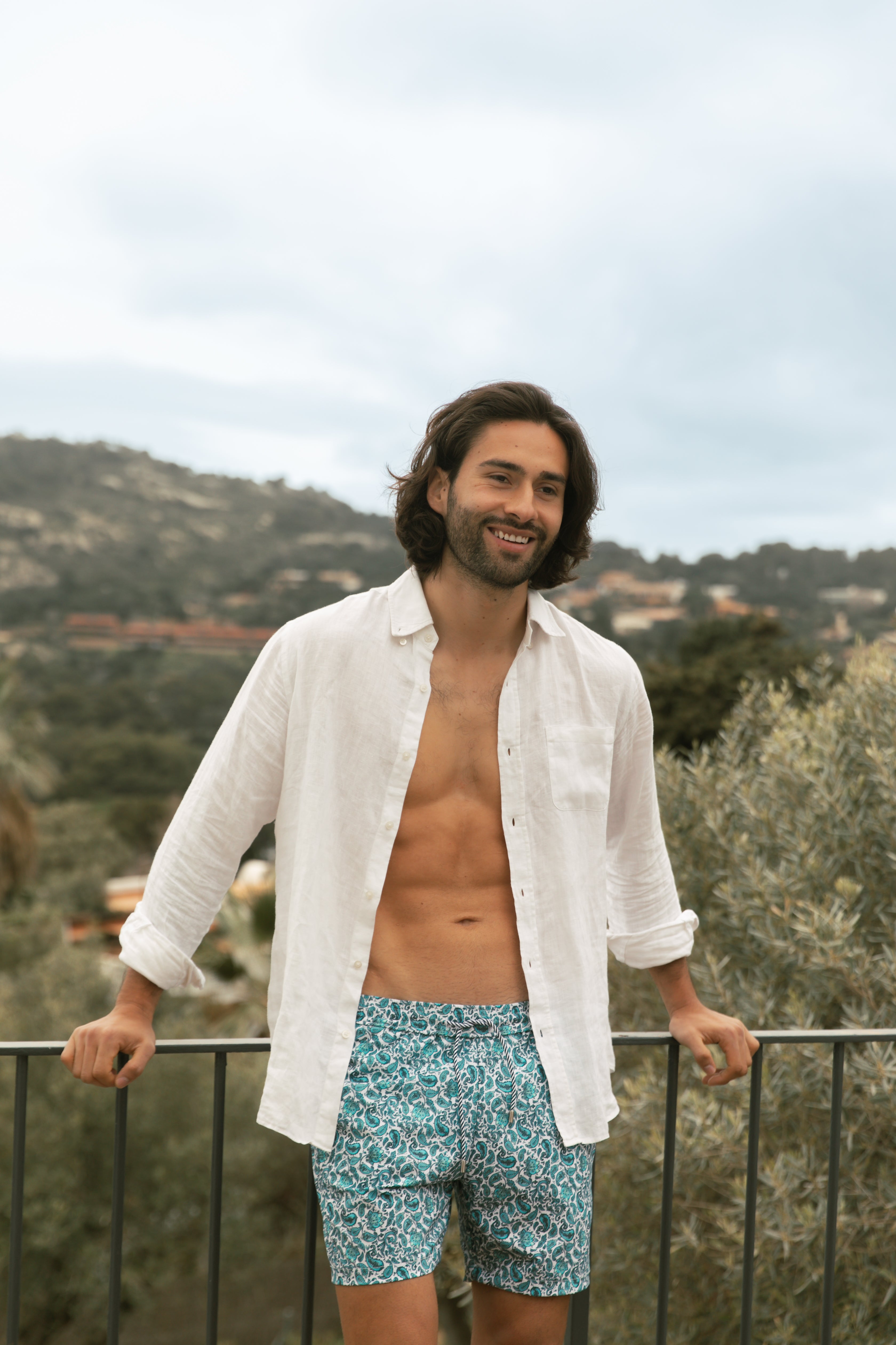 Long-haired model wearing printed blue swimsuit AQVA Swimwear