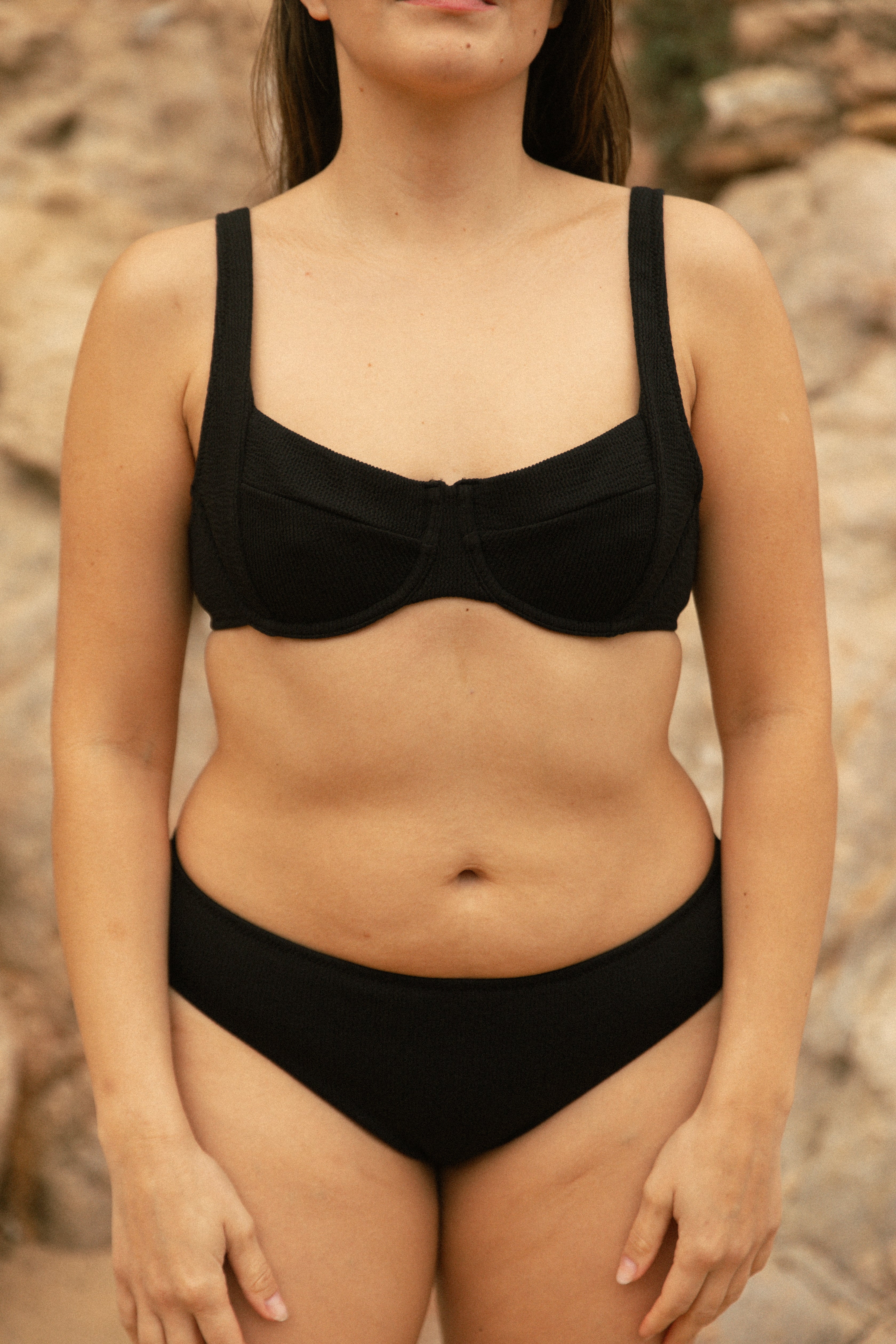 Young female model wearing black bikini AQVA Swimwear