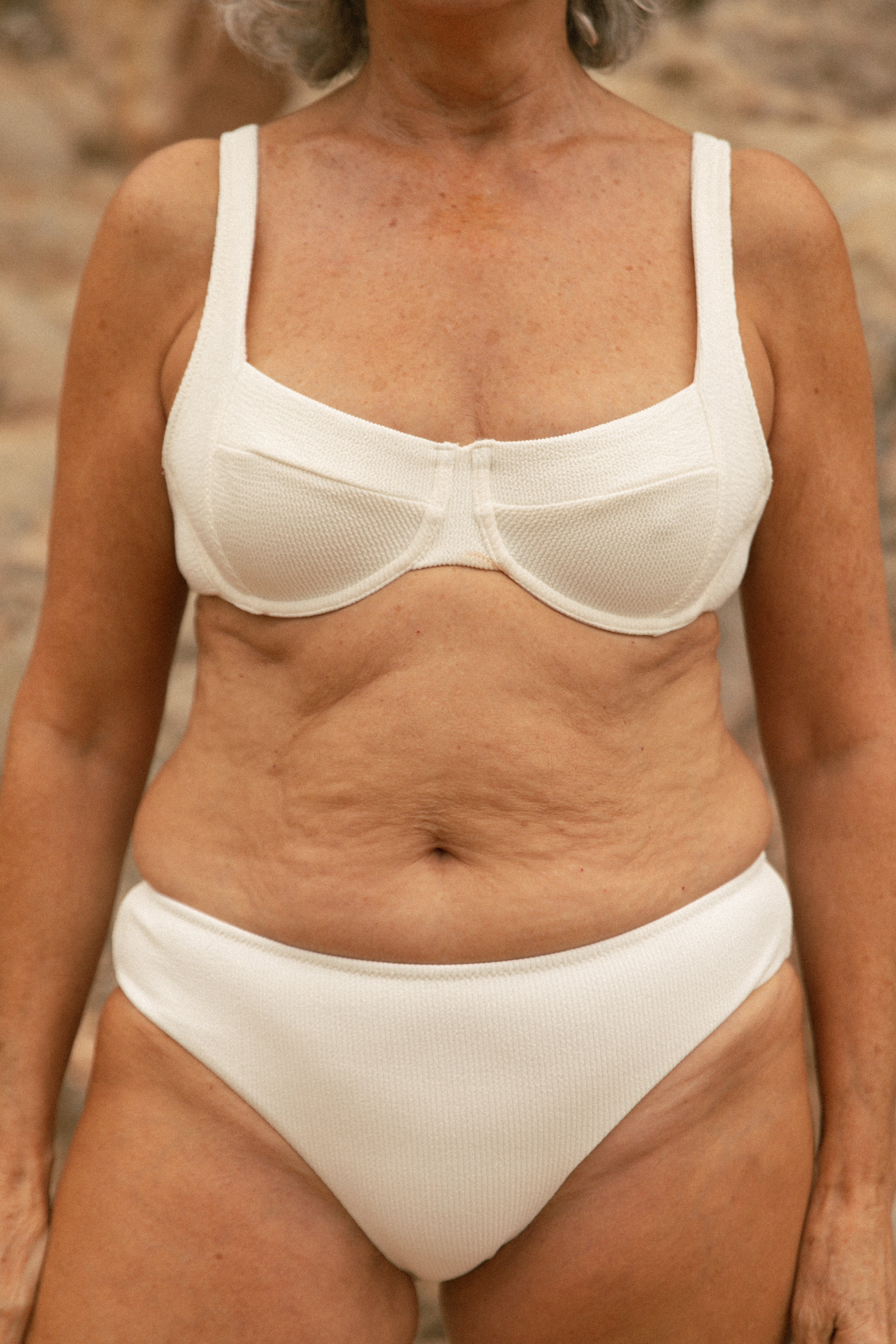 Older female model wearing nude bikini AQVA Swimwear