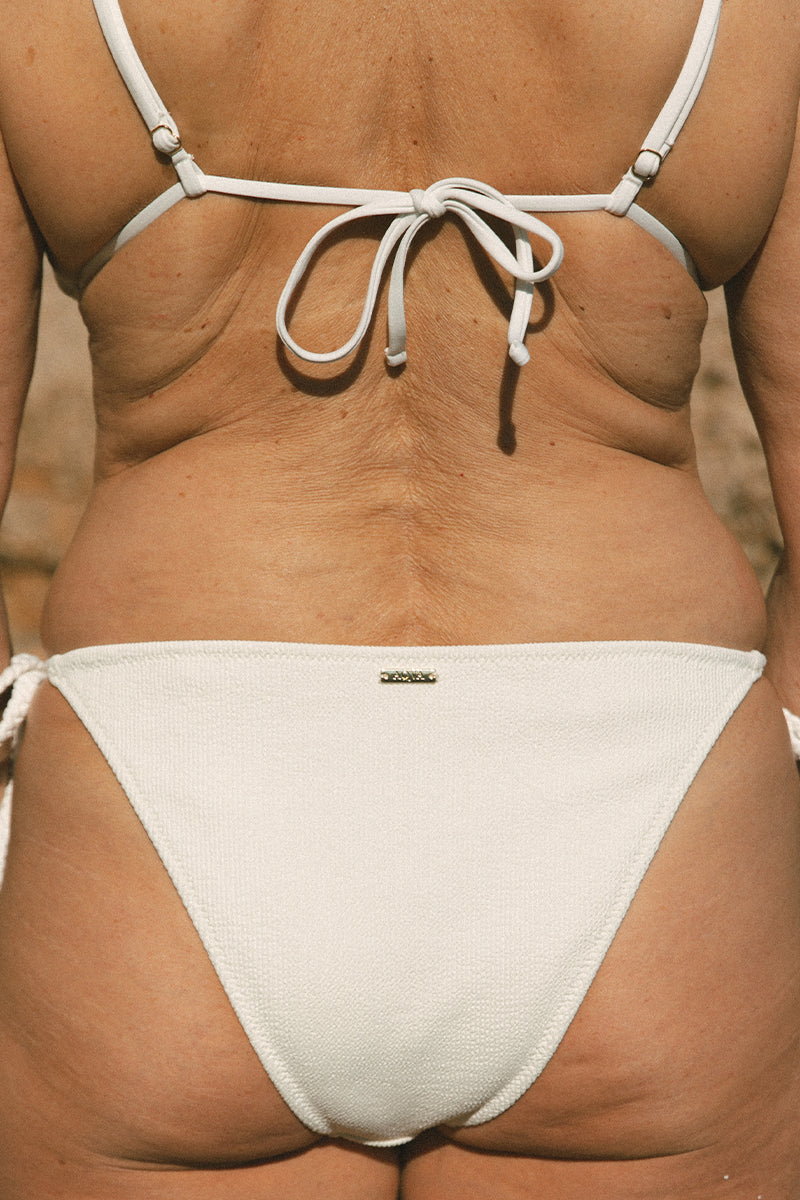 Detail of model with her back turned up wearing braided side ties by Aqva Swimwear