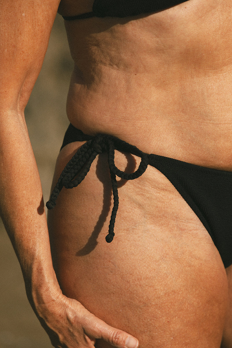 Detail of model wearing Black Tie Bikini Bottom AQVA Swimwear