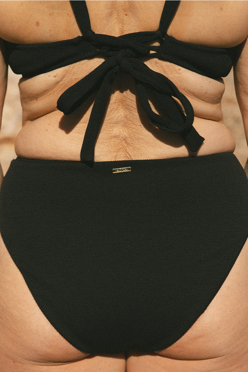 Back detail of woman wearing High-Waisted Black Bikini Bottom AQVA Swimwear