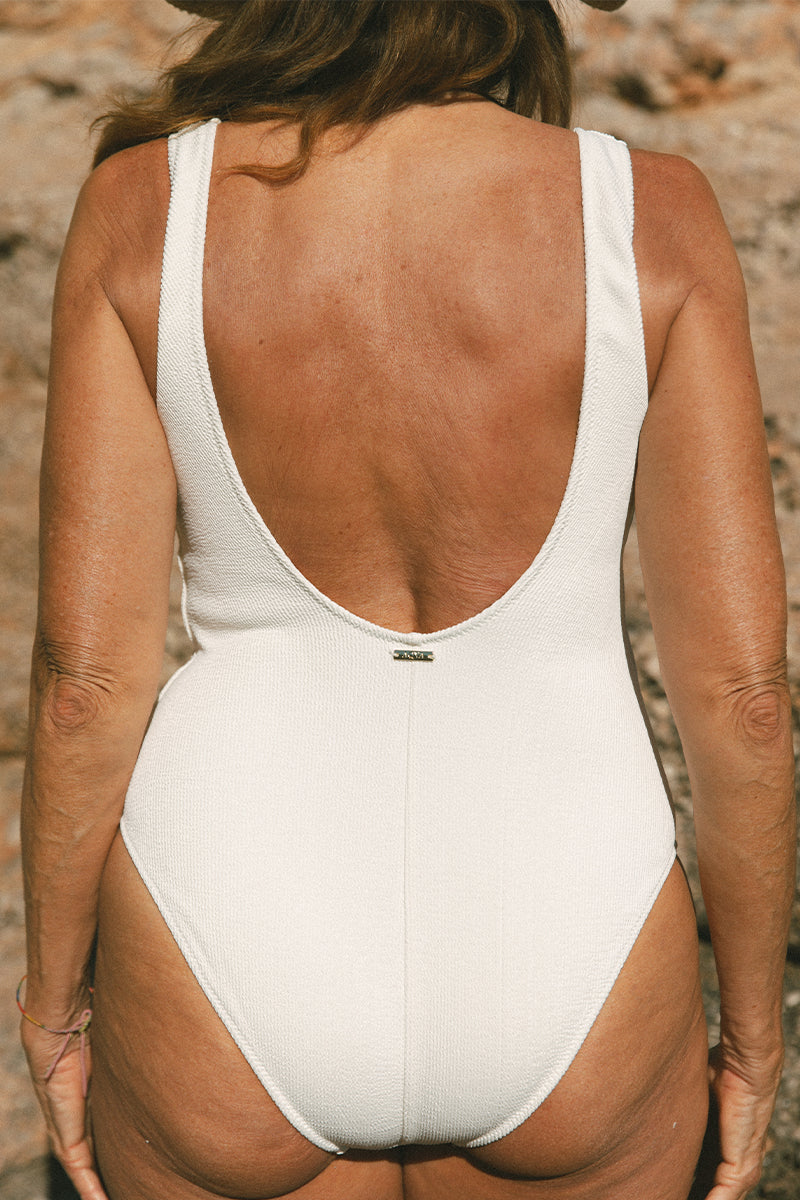 Detail of model on her back wearing light nude swimming costume by AQVA Swimwear