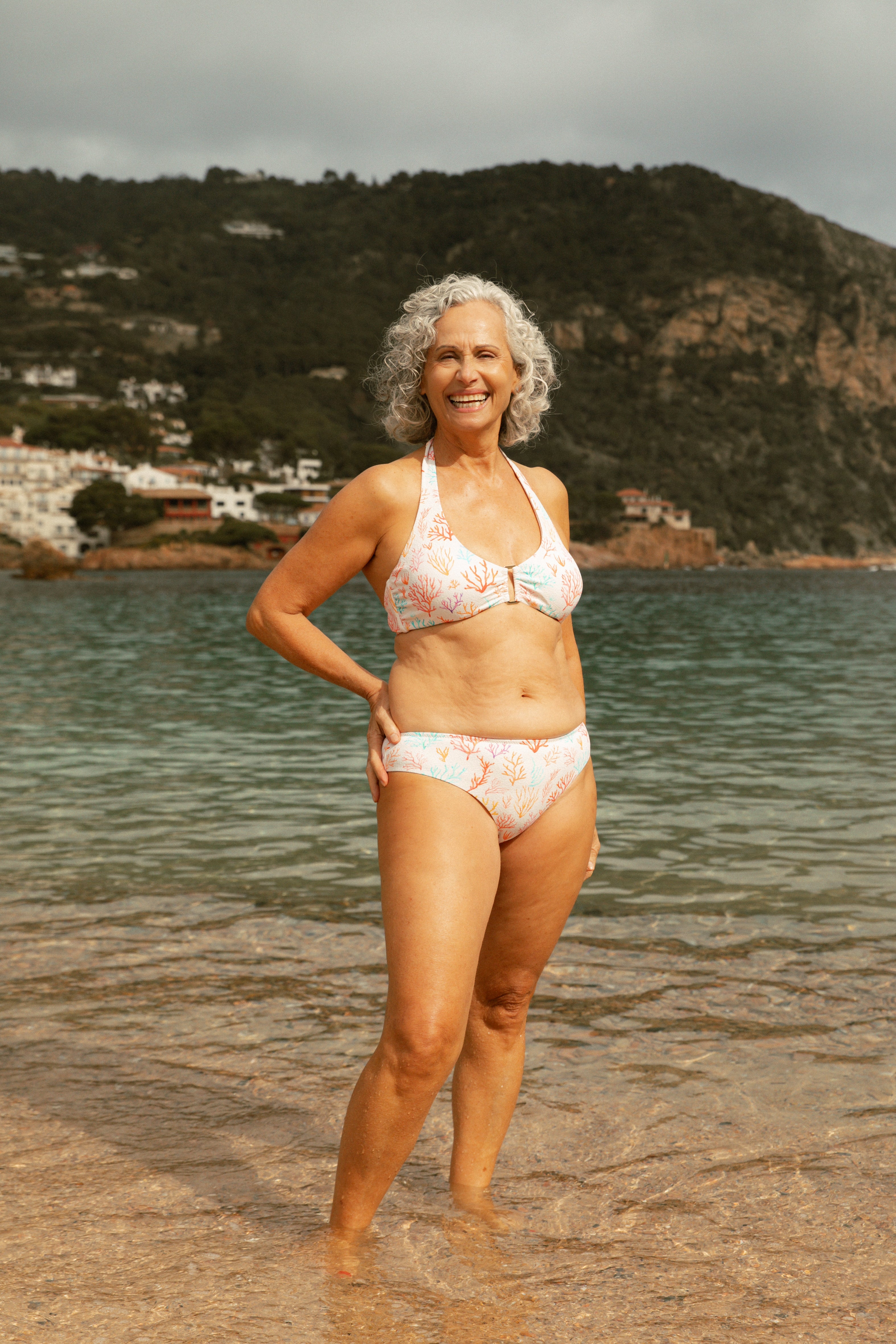 Older female model on the beach wearing printed bikini AQVA Swimwear