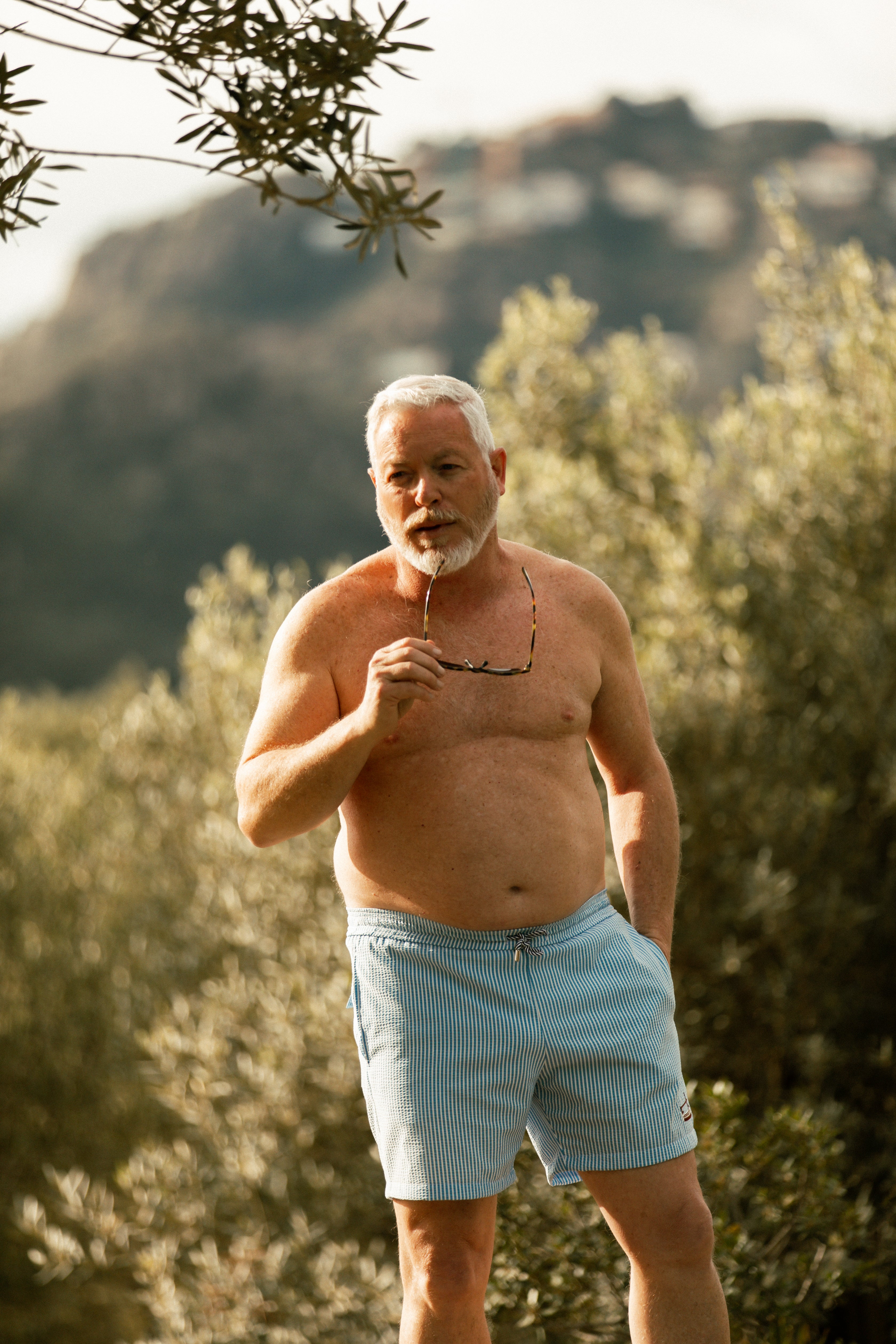 Older male model wearing blue striped swimsuit AQVA Swimwear